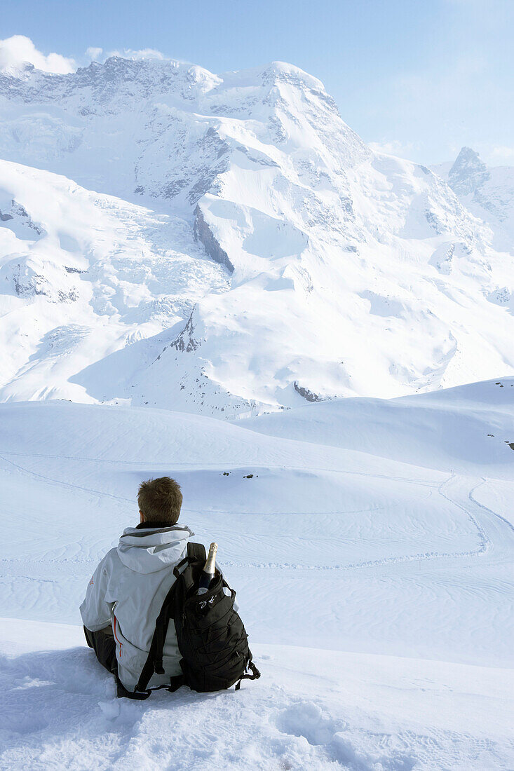 Man sitting on mountainside in Zermatt, Valais, Switzerland