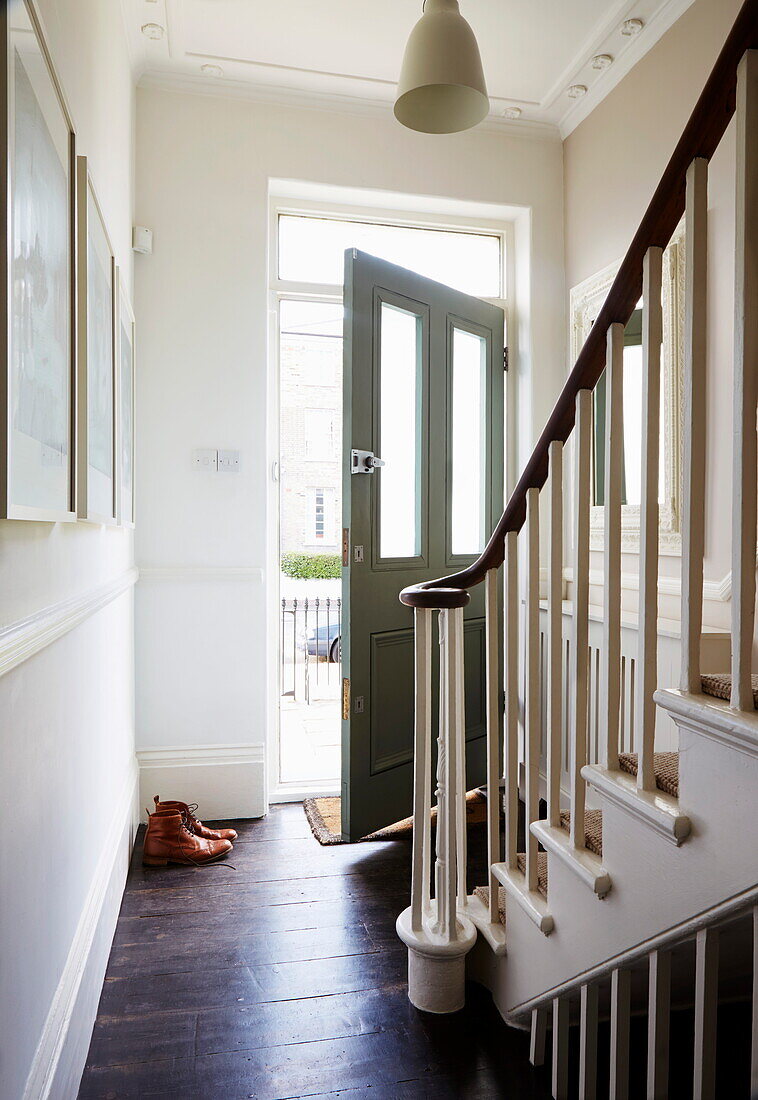 Stiefel an der offenen Haustür eines Londoner Stadthauses, England, UK
