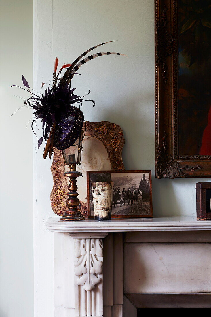 Feather hat with vintage photographs on mantlepiece in Cumbrian home, England, UK