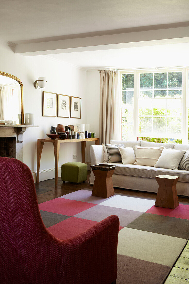 Wohnzimmer mit kariertem Teppich und gepolsterten Stühlen