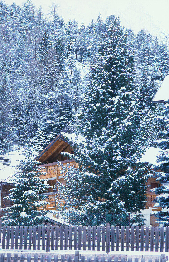 Verschneite Landschaft mit Holzchalet in den Dolomiten