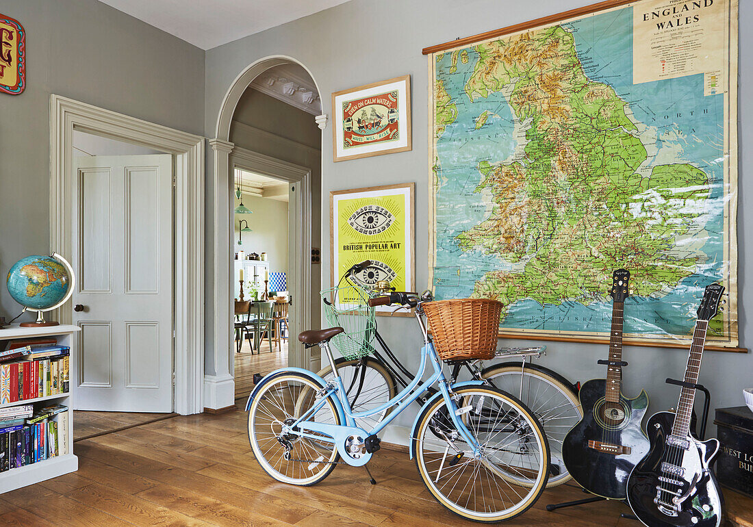 Fahrräder und Gitarren mit großer Wandkarte von Großbritannien im Eingangsflur eines Einfamilienhauses, Rye, East Sussex, England, UK