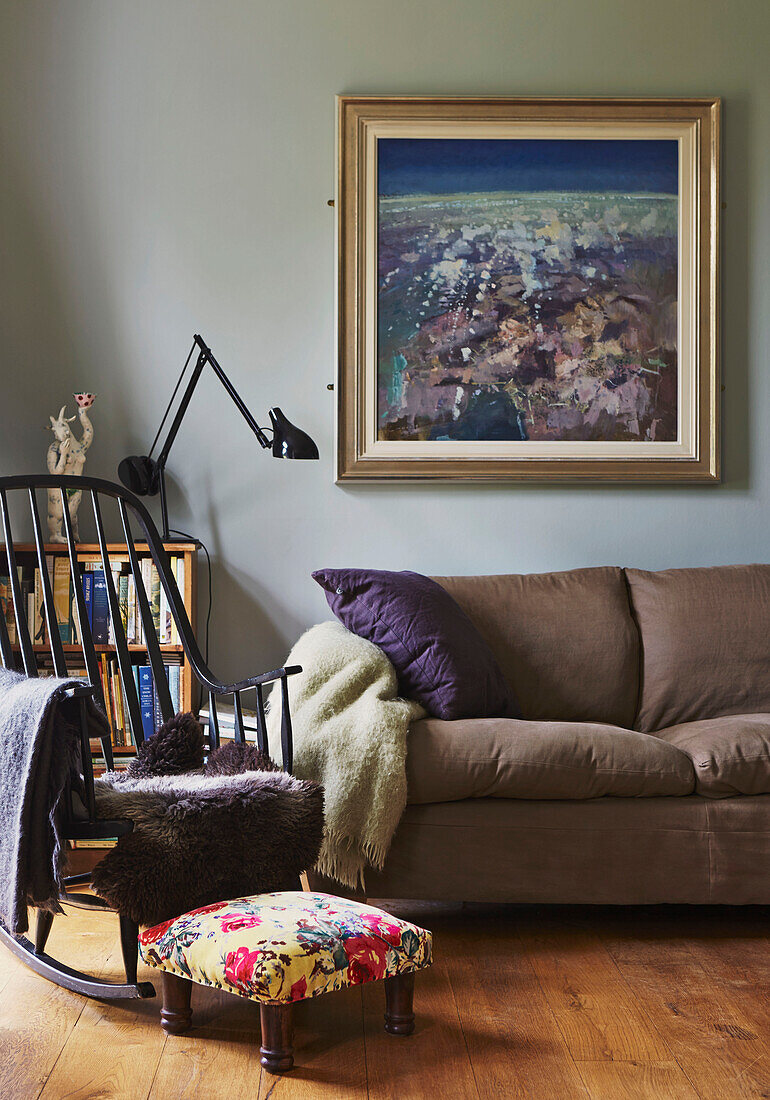 Gerahmtes Kunstwerk über dem Sofa mit Schaukelstuhl im Wohnzimmer eines Familienhauses, Rye, East Sussex, England, UK
