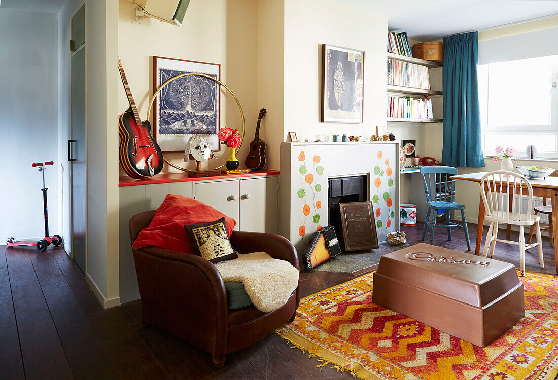 Brown leather armchair with large square of chocolate on patterned rug in Hackney living room, East London, UK