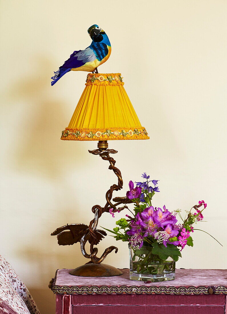 Vintage-Lampe mit Vogelornament und Schnittblumen in einem Bauernhaus in Cumbria, England, UK