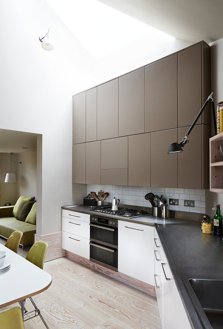 Braune Einbauschränke in einer modernen offenen Küche in einem Haus in London, England, UK