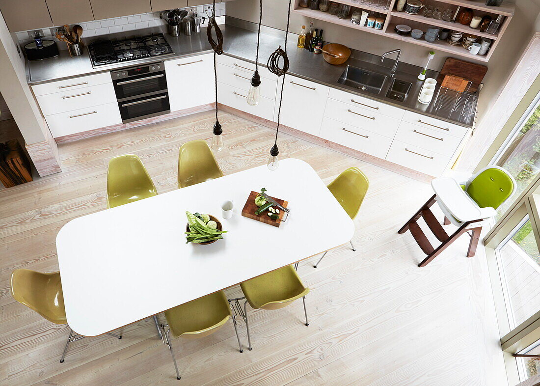 Erhöhte Ansicht eines Esstisches mit lindgrünen Stühlen in einer modernen Küche in London, England, UK