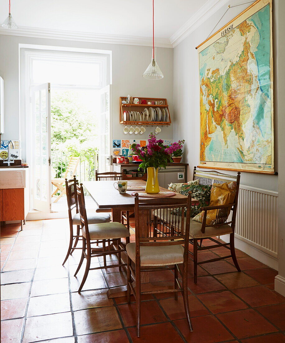 Wandkarte und Tisch in der terrakottagefliesten Küche eines Hauses in London, England, UK