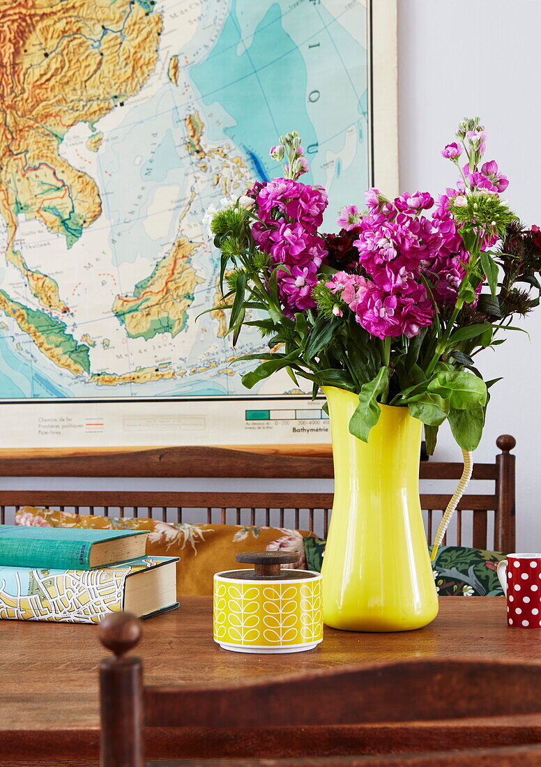 Cut flowers and vintage sugar bowl with wall map in London home, England, UK