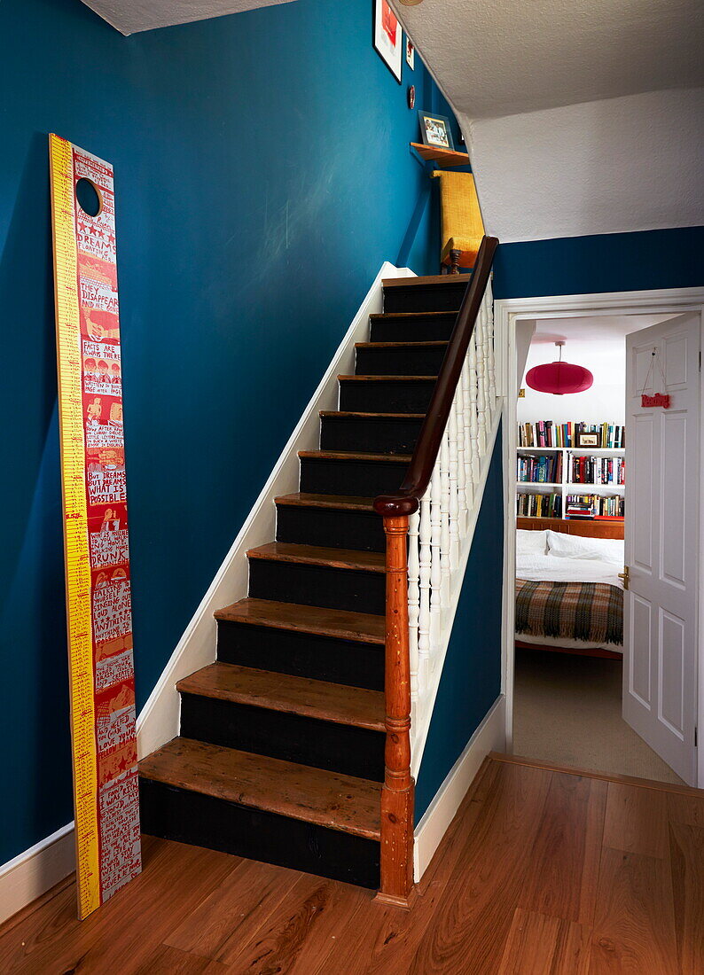 Blauer Flur mit Holztreppe in einem farbenfrohen Haus in London, England, Vereinigtes Königreich