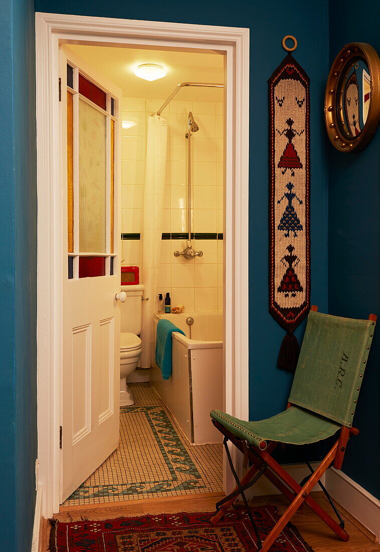 Grüner Klappstuhl am Eingang zum Badezimmer in einem Londoner Haus, England, UK