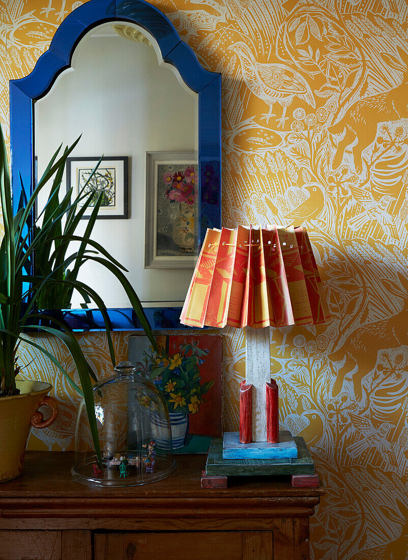 Handgefertigte Lampe mit hellem Spiegelrahmen und gemusterter Tapete in einem Haus in London, England, UK