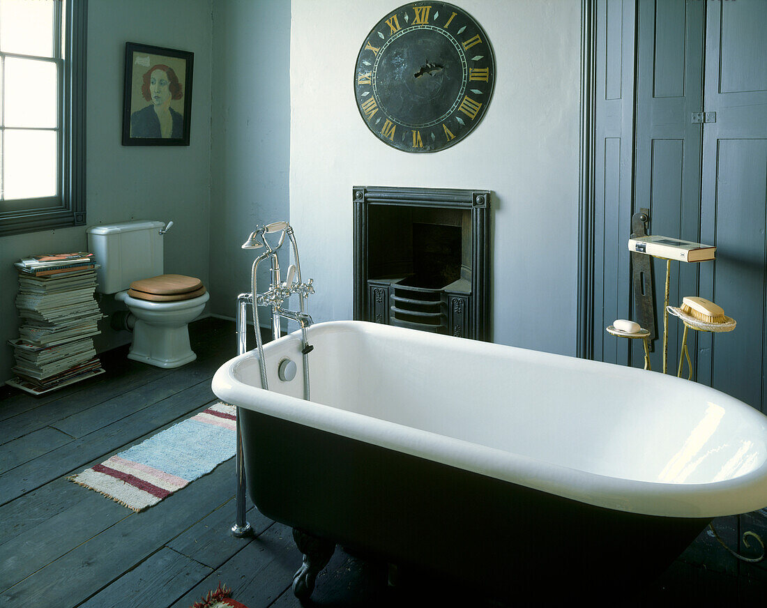 Blaue viktorianische Badewanne mit Wanduhr im Badezimmer