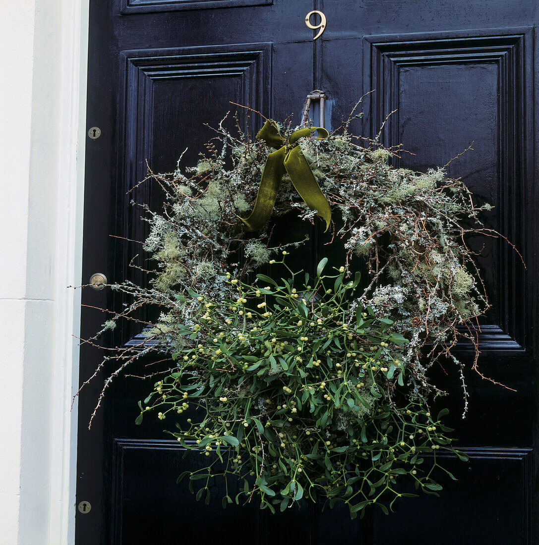Christmas wreath of mistletoe and lichen on black front door