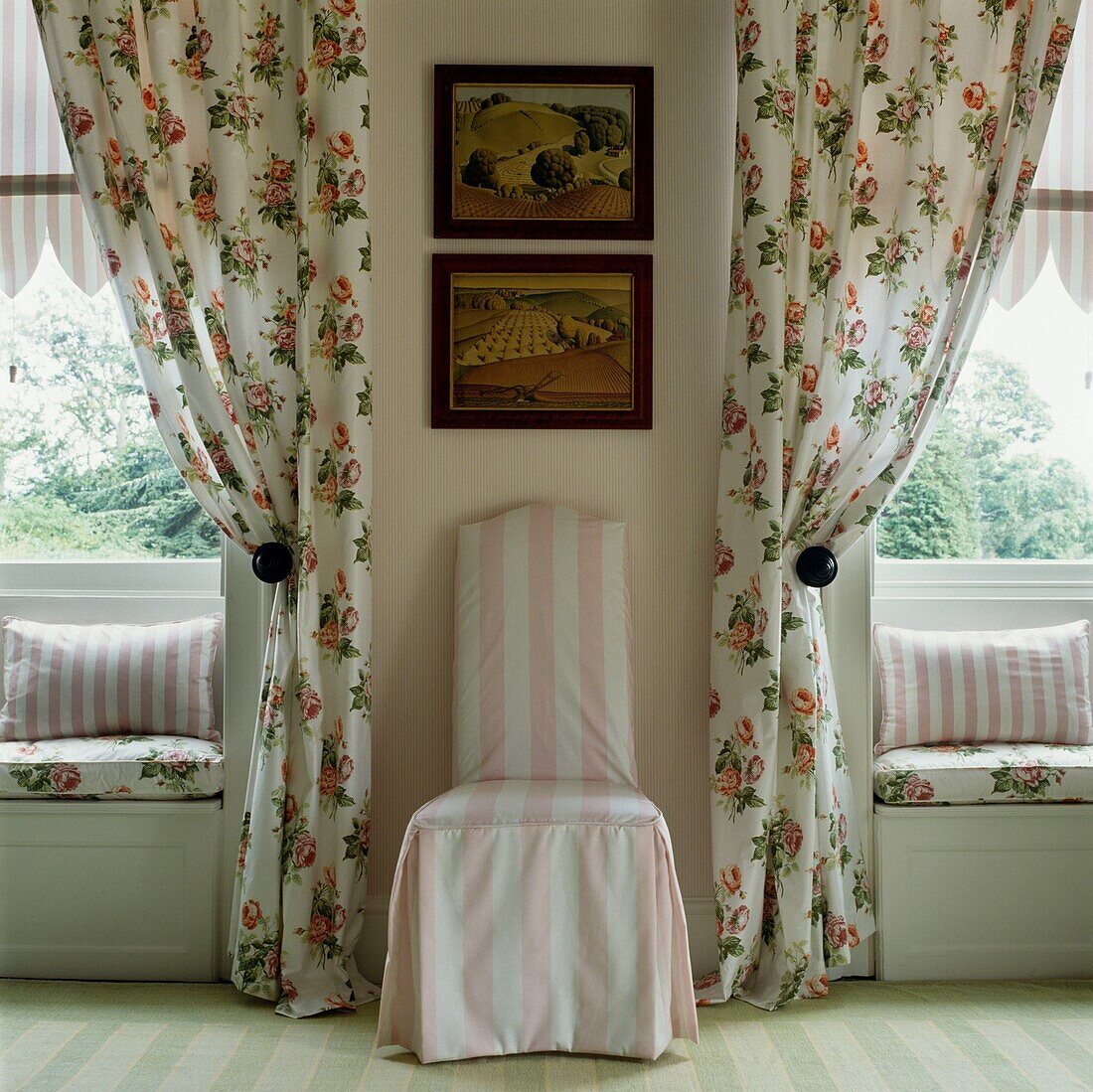 Geblümte Vorhänge und Fensterbank mit gepolstertem rosa-weiß gestreiftem Stuhl