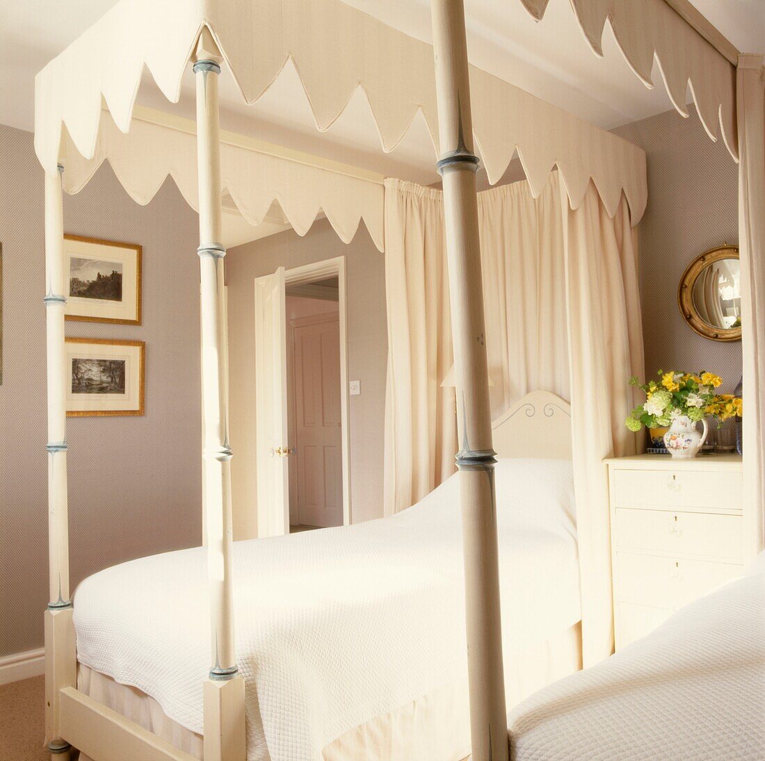 Cremefarbenes Himmelbett in neutralem Schlafzimmer mit gewölbtem Spiegel