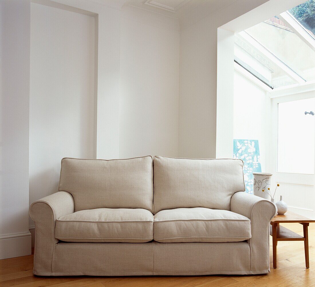 Cream coloured two-seater sofa in attic conversion with skylight