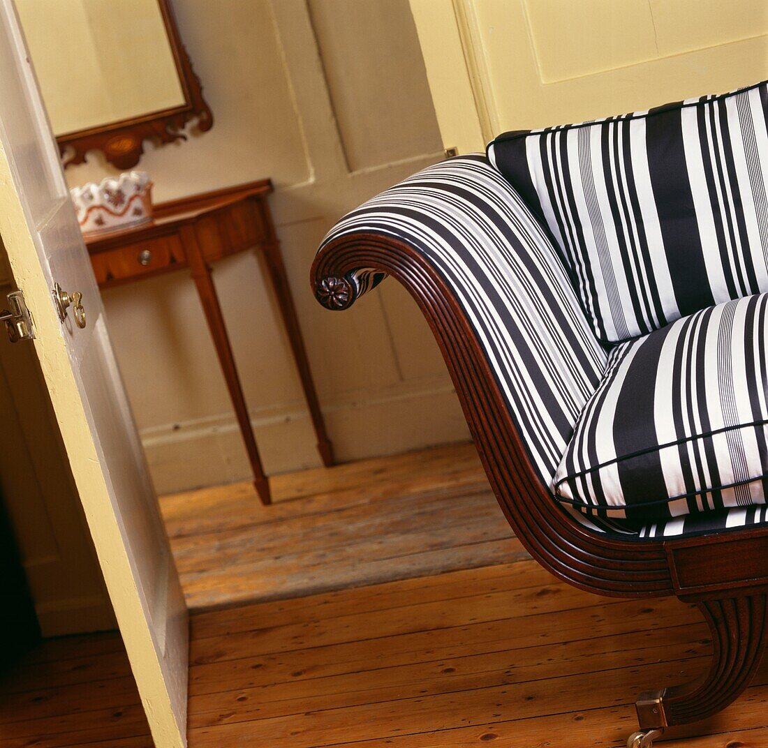 Striped chair with cushion at open door to hallway