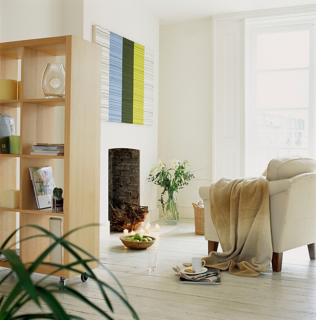 Bewegliches Regal im Wohnzimmer mit weiß gestrichenen Dielen und übergeworfenem Sofa