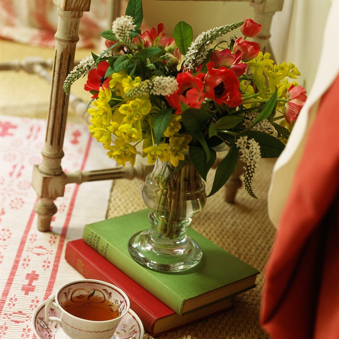 Blumenvase auf Büchern mit Teetasse