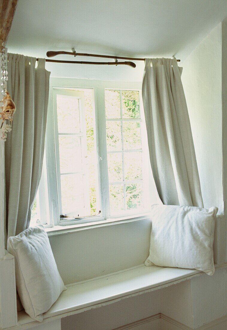 Open window at window seat with linen curtains