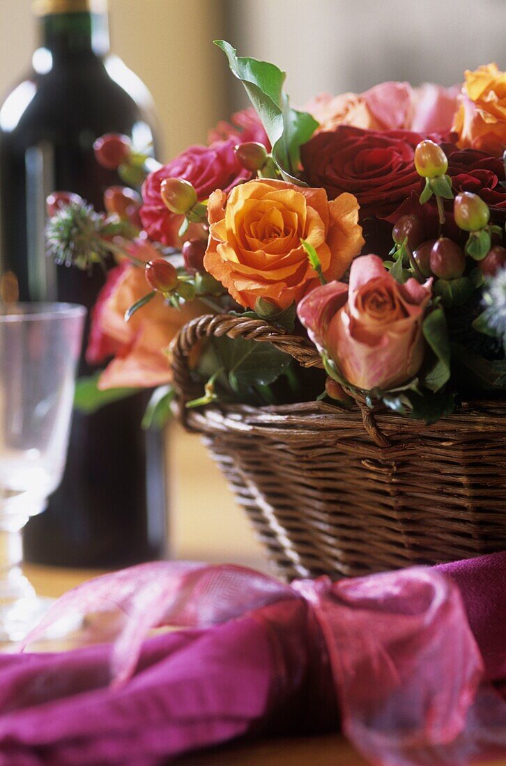 Blumenarrangement mit Rosen im Korb auf dem Tisch
