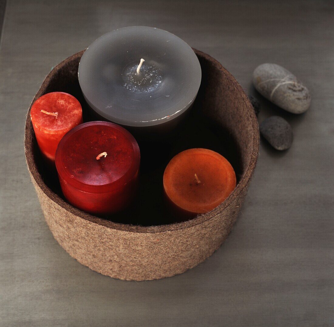 Group of coloured candles in a container