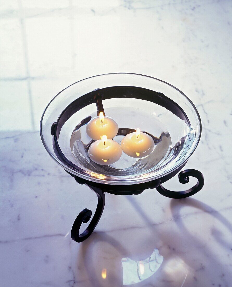 Schwimmende Kerzen in Glasschale auf Marmortischplatte