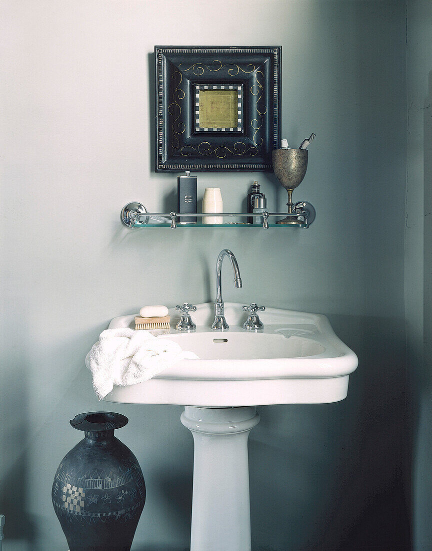 Washstand with decorative picture frame and bathroom shelf