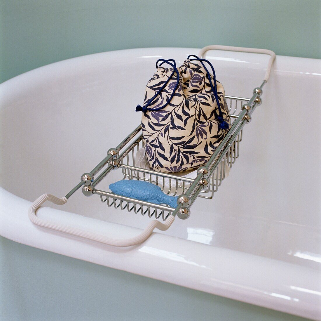 Geblümter Waschbeutel auf dem Badewannenständer einer freistehenden Badewanne mit Rolltop
