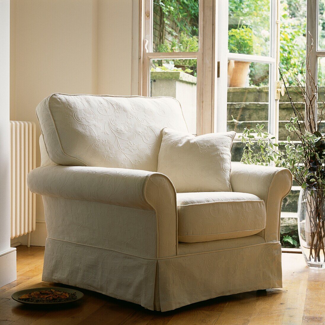 Cream upholstered armchair in basement widow