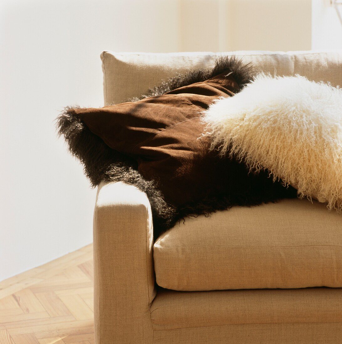 Fur and suede cushions on cream sofa