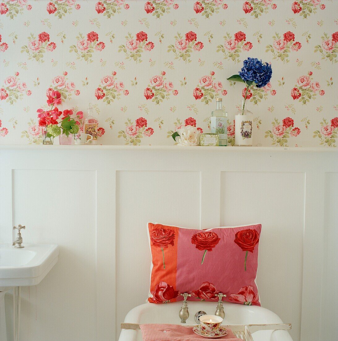 Cushion in bathroom with panelled wall and floral patterned wallpaper