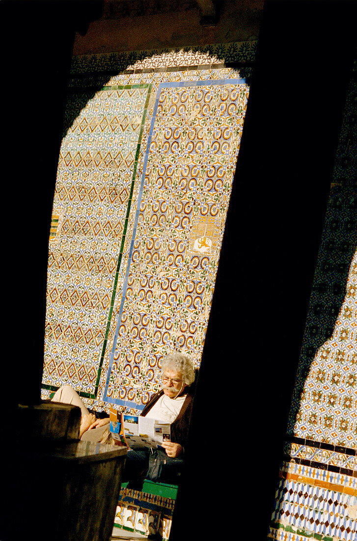 Tourists relaxing in the sun in the Alcazar Palace in Seville
