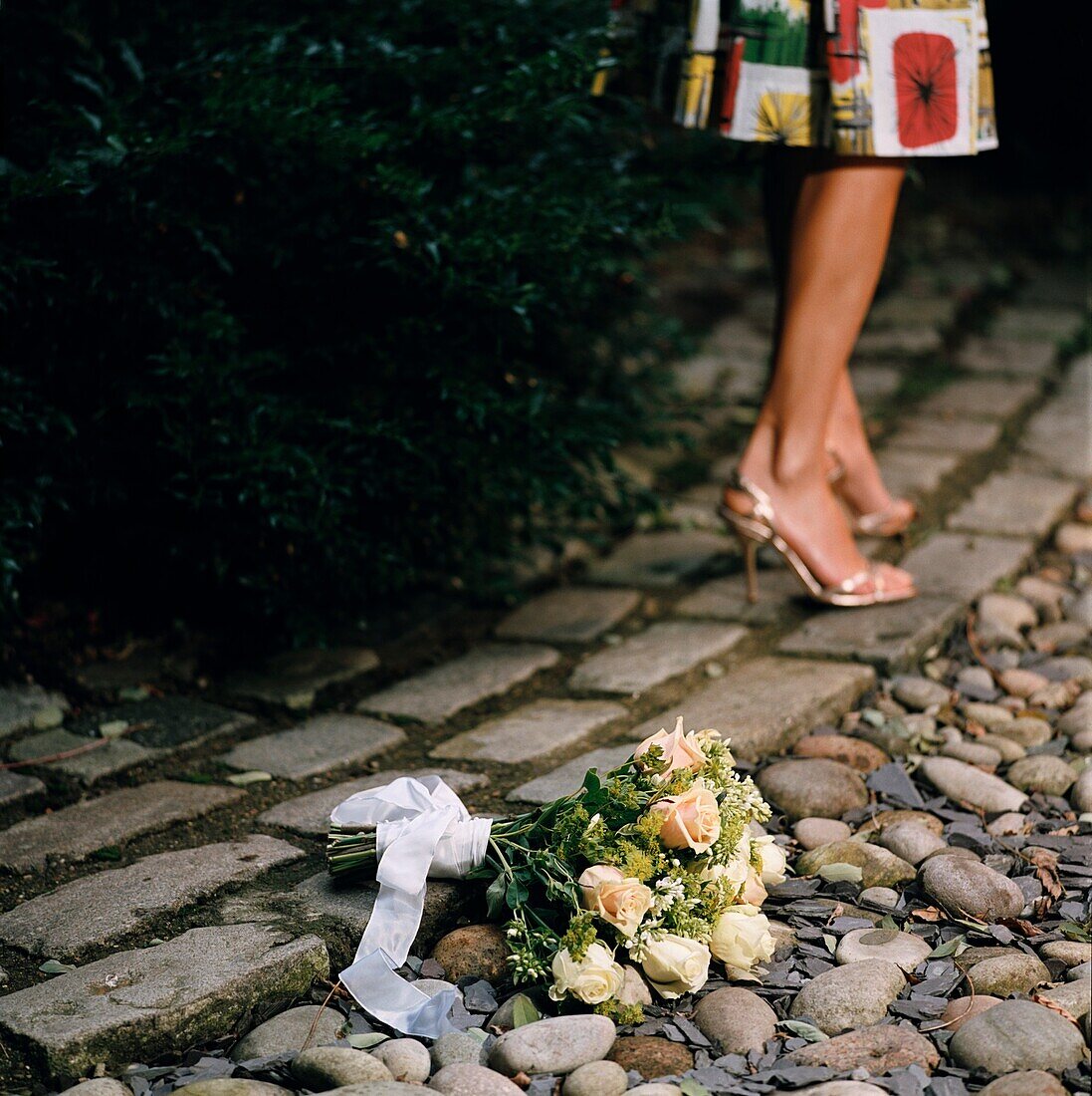 Frau geht von einem Blumenstrauß auf dem Boden weg