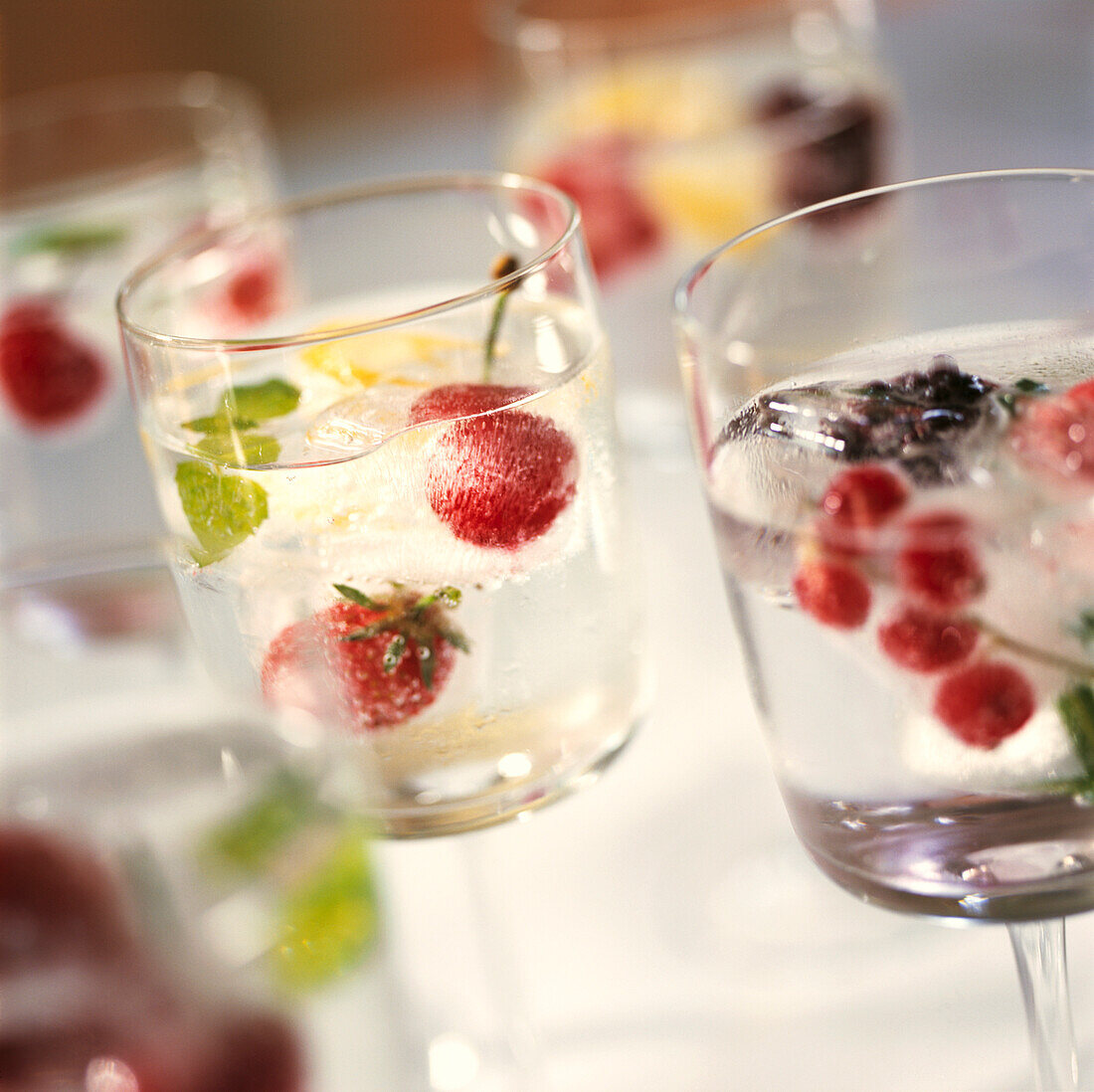 Fruited ice-cubes floating in sparkling mineral water