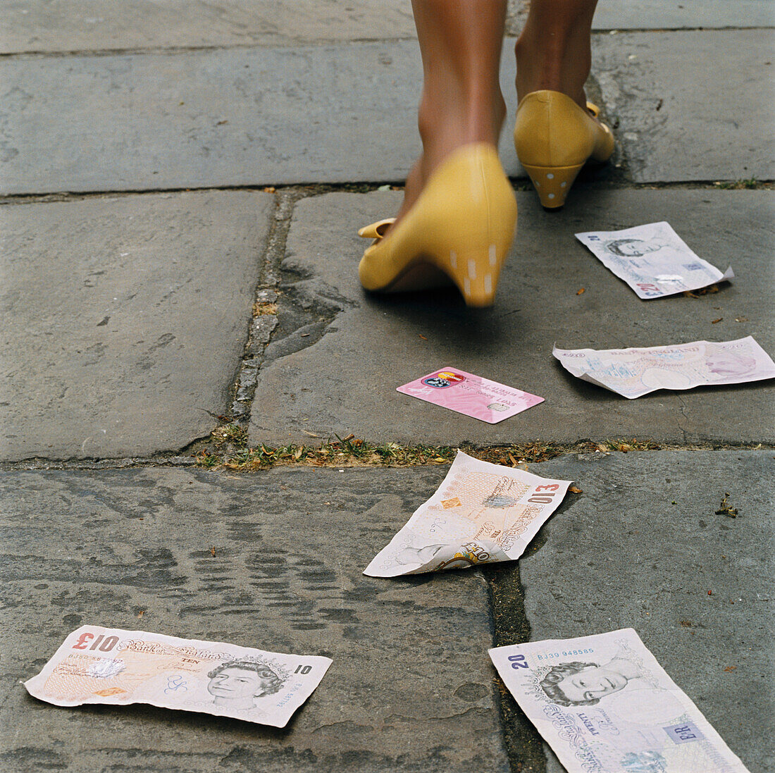 Woman walking dropping money and credit cards on the street