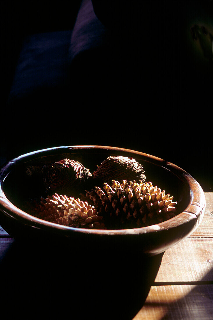 Wooden bowl filled with pine cones