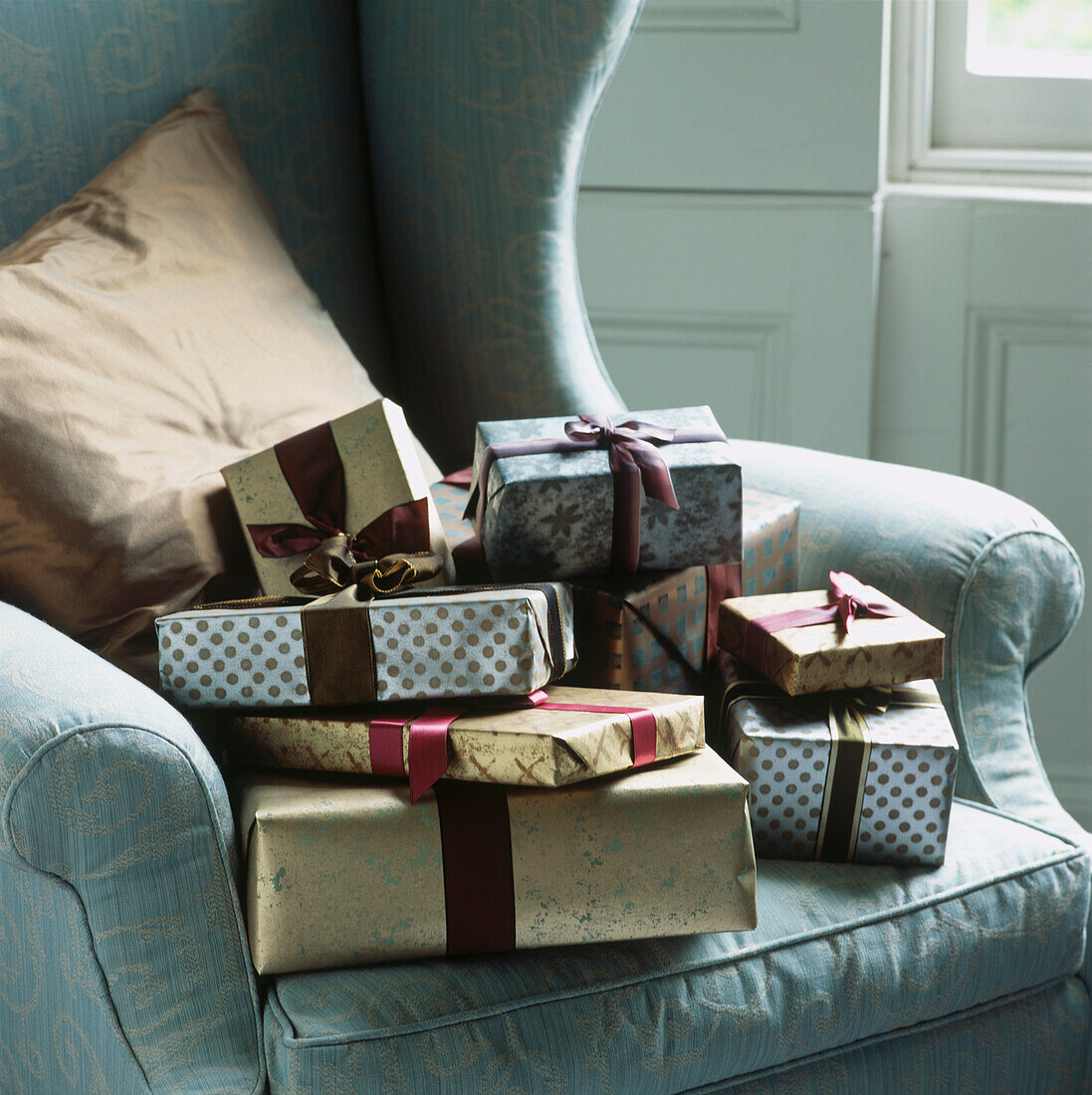 In Silber und Gold verpackte Weihnachtsgeschenke auf einem Sessel
