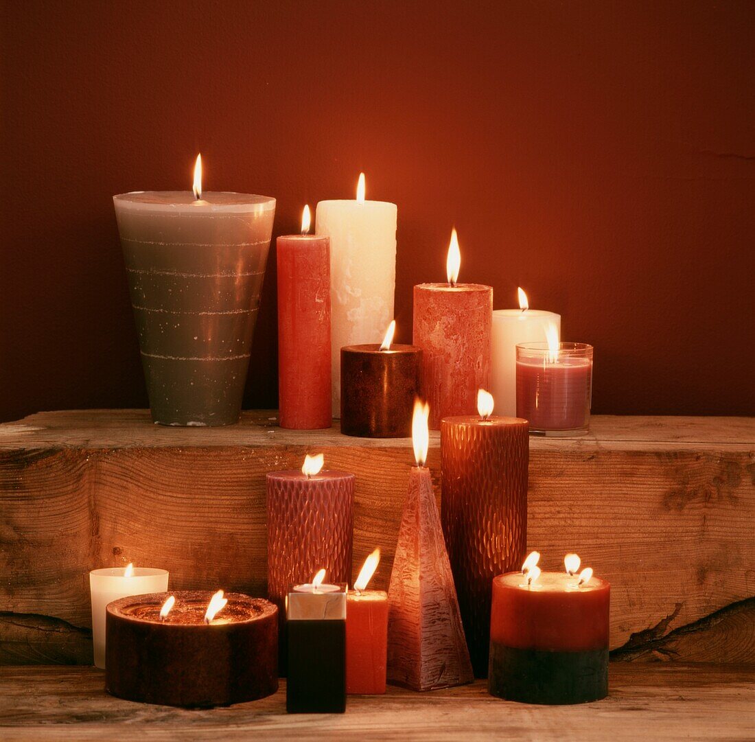 Lit candles on untreated wooden shelf