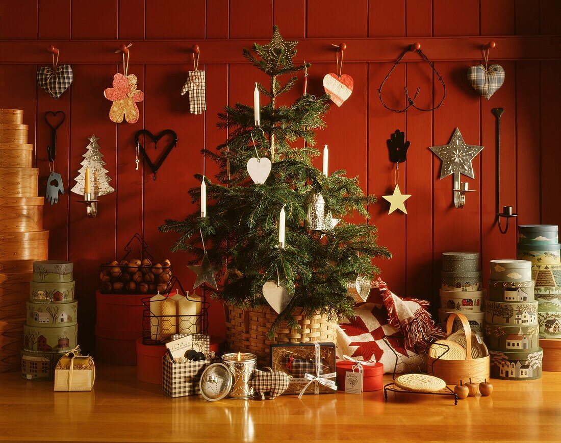 Christmas tree and decorations set against red panelled wall