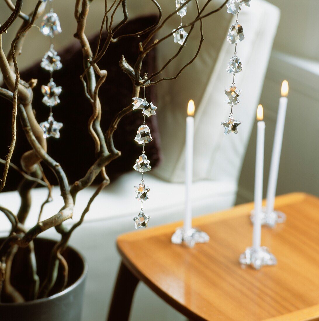 Glass Christmas ornaments and lit taper candles