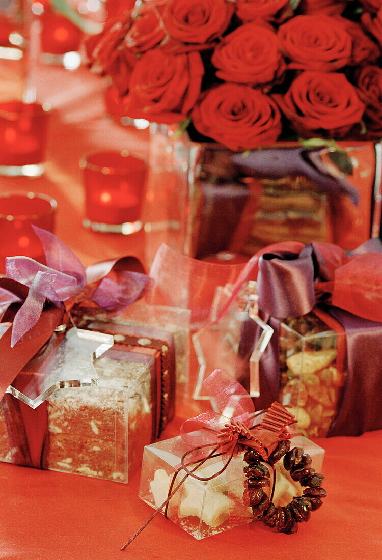 Verschiedene Süßigkeiten und Weihnachtsgeschenke mit roten Rosen in einem Haus in Großbritannien