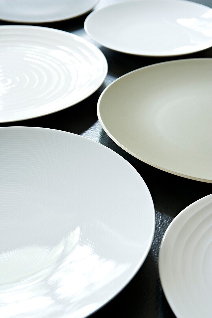 Close up of white plates on a black tabletop