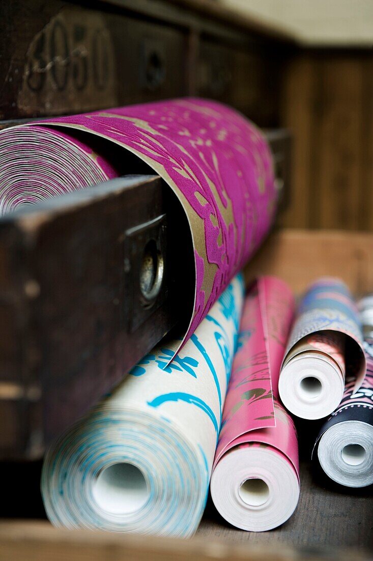 Close up of wallpaper rolls on a bench and in a drawer