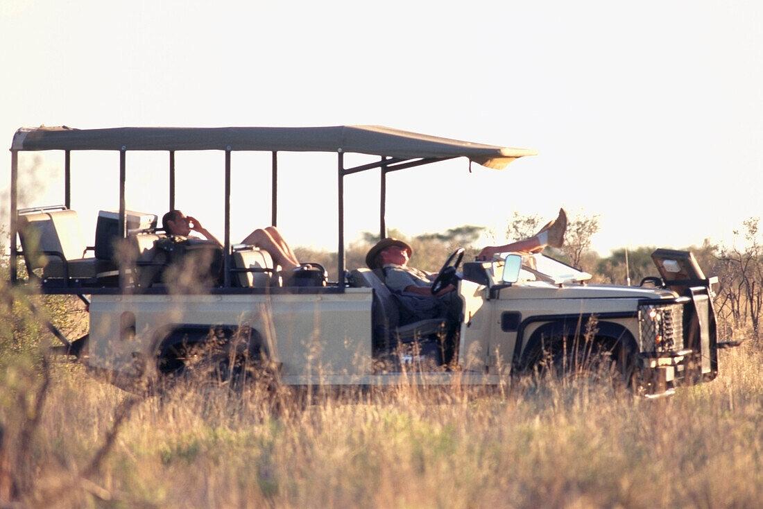 Feldführer bei einem Nickerchen in einem der offenen Safarifahrzeuge im Tswalu Kalahari Game Reserve