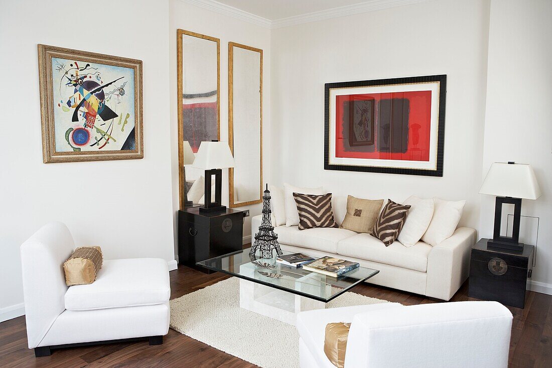 White three-piece suite and artwork in living room of London home
