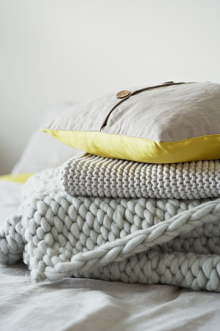 Yellow and grey cushion and blankets   folded   London   UK