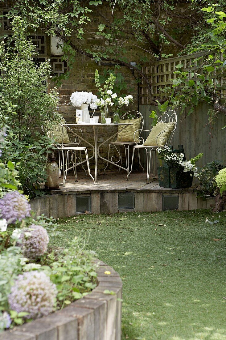 Gartenmöbel auf einer erhöhten Terrasse in einem Londoner Garten UK