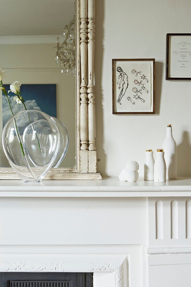 Homeware and artwork on white mantlepiece in London home   UK